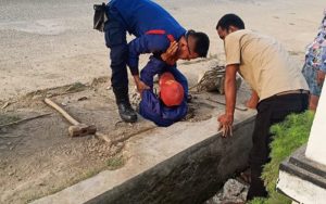 Petugas Damkar Plered Rela Masuk Saluran Air Trotoar Demi Ambil Handphone Milik Warga