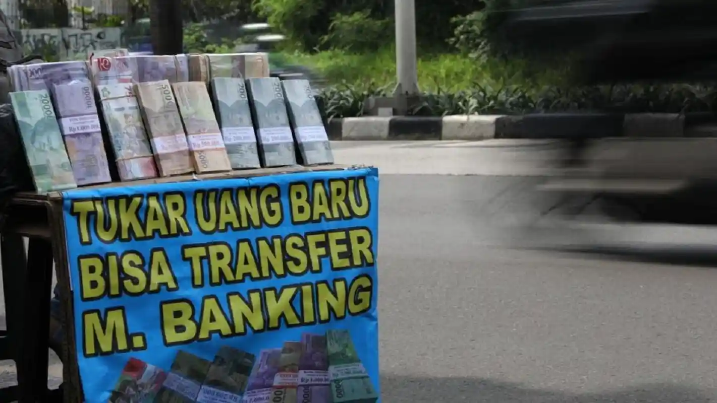 Ilustrasi praktik tukar uang baru Lebaran dan hukum Islam